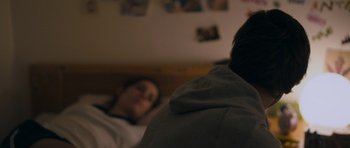 Movie still from “Alps” (2011), directed by Yorgos Lanthimos – A man and a woman in a bed with pictures on the wall; Close Up shot, Over the shoulder angle