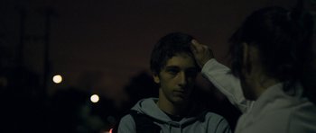 Movie still from “Alps” (2011), directed by Yorgos Lanthimos – A young man with his hand on his head; Close Up shot, Over the shoulder angle