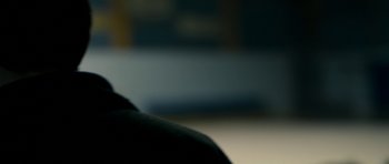 Movie still from “Alps” (2011), directed by Yorgos Lanthimos – A blurry image of a person sitting in a chair; Extreme Close Up shot, Over the shoulder angle