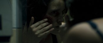 Movie still from “Alps” (2011), directed by Yorgos Lanthimos – A woman with a scar on her face and hand; Extreme Close Up shot, Over the shoulder angle