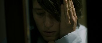 Movie still from “Alps” (2011), directed by Yorgos Lanthimos – A woman is holding her head in her hands; Extreme Close Up shot, High angle
