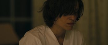 Movie still from “Alps” (2011), directed by Yorgos Lanthimos – A person with long black hair wearing a white shirt; Close Up shot, High angle