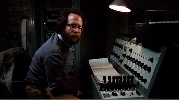Movie still from “Altered States” (1980), directed by Ken Russell – A man sitting in front of an electrical panel; Medium shot, Low angle