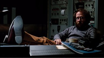 Movie still from “Altered States” (1980), directed by Ken Russell – A man sitting in front of a computer keyboard; Medium shot, High angle