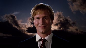 A man in a suit and tie with clouds in the background