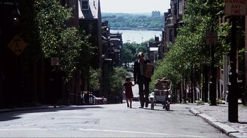 Movie still from “Altered States” (1980), directed by Ken Russell – A man walking down the street with a baby in a stroller; Wide shot, Over the shoulder angle