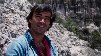 Movie still from “Altered States” (1980), directed by Ken Russell – A person wearing a blue shirt near a cliff; Close Up shot, Low angle