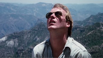Movie still from “Altered States” (1980), directed by Ken Russell – A man wearing sunglasses looking into the distance; Close Up shot, Low angle