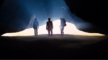 Movie still from “Altered States” (1980), directed by Ken Russell – A group of people standing inside of a cave at night; Wide shot, Low angle
