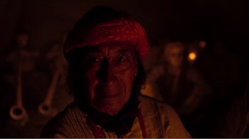 Movie still from “Altered States” (1980), directed by Ken Russell – An older man wearing a red hat and a yellow shirt; Close Up shot, Over the shoulder angle