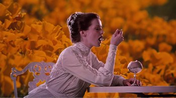 Movie still from “Altered States” (1980), directed by Ken Russell – A woman sitting at a table eating something; Medium shot, High angle