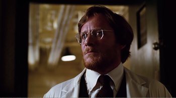 Movie still from “Altered States” (1980), directed by Ken Russell – A person wearing a suit and tie; Close Up shot, Low angle