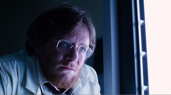 Movie still from “Altered States” (1980), directed by Ken Russell – A person wearing glasses and a white shirt; Close Up shot, Low angle