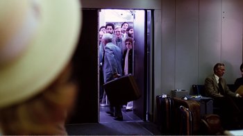 Movie still from “Altered States” (1980), directed by Ken Russell – A group of people standing in front of an open door; Wide shot, Over the shoulder angle