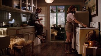 Movie still from “Altered States” (1980), directed by Ken Russell – A man and a woman are standing in a kitchen; Wide shot, Low angle