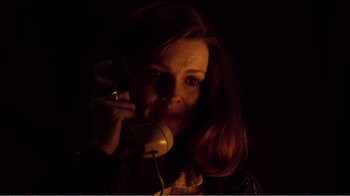 Movie still from “Altered States” (1980), directed by Ken Russell – A woman is talking on a phone in the dark; Close Up shot, Low angle