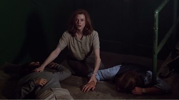 Movie still from “Altered States” (1980), directed by Ken Russell – A woman kneeling on the ground next to two children; Medium shot, High angle