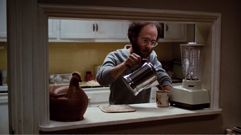 Movie still from “Altered States” (1980), directed by Ken Russell – A man pouring something into a coffee pot; Medium shot, High angle