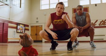 Movie still from “Alvin and the Chipmunks: The Squeakquel” (2009), directed by Betty Thomas – A group of young men standing on a basketball court; Medium shot, Over the shoulder angle