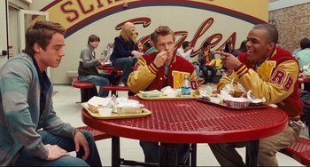 Movie still from “Alvin and the Chipmunks: The Squeakquel” (2009), directed by Betty Thomas – A group of people sitting at a table eating food; Medium shot, High angle