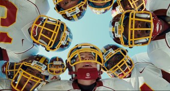 Movie still from “Alvin and the Chipmunks: The Squeakquel” (2009), directed by Betty Thomas – A group of people wearing football helmets and one has his mouth open; Close Up shot, Overhead angle
