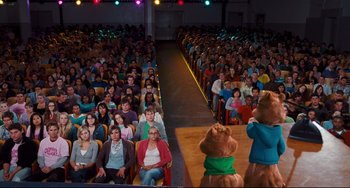 Movie still from “Alvin and the Chipmunks: The Squeakquel” (2009), directed by Betty Thomas – A group of people sitting in front of a crowd; Wide shot, High angle