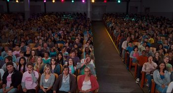 Movie still from “Alvin and the Chipmunks: The Squeakquel” (2009), directed by Betty Thomas – A large group of people sitting in rows in a room; Wide shot, High angle