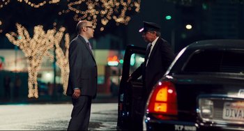 Movie still from “Alvin and the Chipmunks: The Squeakquel” (2009), directed by Betty Thomas – Two men standing next to each other in front of a car; Wide shot, Over the shoulder angle