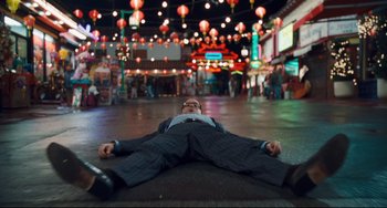 Movie still from “Alvin and the Chipmunks: The Squeakquel” (2009), directed by Betty Thomas – A man laying on the ground in a suit; Wide shot, Overhead angle
