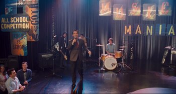 Movie still from “Alvin and the Chipmunks: The Squeakquel” (2009), directed by Betty Thomas – A group of men on a stage with a microphone; Wide shot, High angle