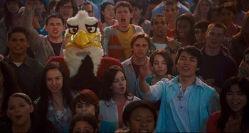 Movie still from “Alvin and the Chipmunks: The Squeakquel” (2009), directed by Betty Thomas – A crowd of people standing in front of an eagle mascot; Medium shot, High angle