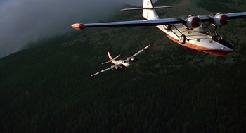 Movie still from “Always” (1989), directed by Steven Spielberg – Two planes flying in the air over a forest; Wide shot, Low angle