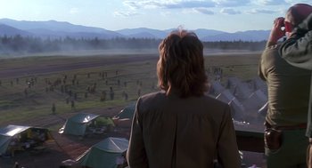 Movie still from “Always” (1989), directed by Steven Spielberg – A woman looking out over a field of tents; Extreme Wide shot, Over the shoulder angle