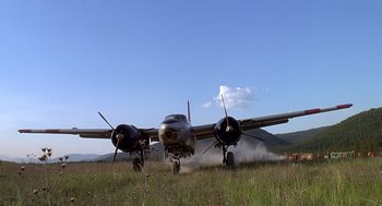 Movie still from “Always” (1989), directed by Steven Spielberg – An airplane is parked in a grassy field; Extreme Wide shot, Low angle
