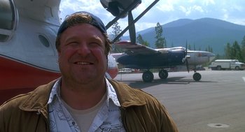 Movie still from “Always” (1989), directed by Steven Spielberg – A man standing in front of an airplane on a runway; Close Up shot, Low angle