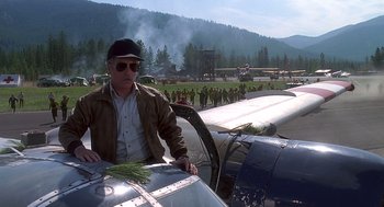 Movie still from “Always” (1989), directed by Steven Spielberg – A man standing next to an airplane on a runway; Wide shot, Low angle