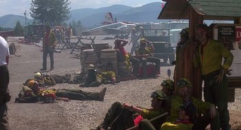 Movie still from “Always” (1989), directed by Steven Spielberg – A group of people sitting on top of a dirt field; Wide shot, High angle