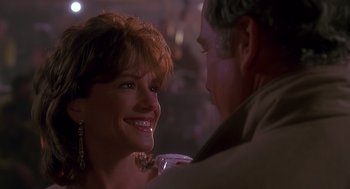 Movie still from “Always” (1989), directed by Steven Spielberg – An older man and a younger woman smiling at each other; Close Up shot, Over the shoulder angle