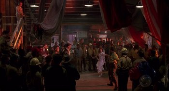Movie still from “Always” (1989), directed by Steven Spielberg – A group of people standing in a room with lights on; Wide shot, High angle