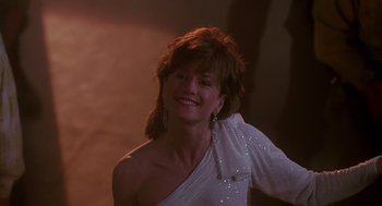 Movie still from “Always” (1989), directed by Steven Spielberg – A woman in a white dress smiling for the camera; Medium shot, Low angle
