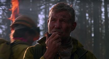 Movie still from “Always” (1989), directed by Steven Spielberg – An older man is smoking a cigarette in the woods; Close Up shot, Low angle