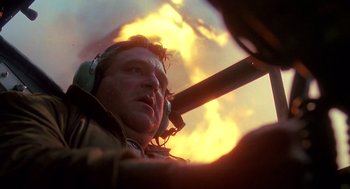 Movie still from “Always” (1989), directed by Steven Spielberg – A man with headphones on looking up at the sky; Close Up shot, Low angle