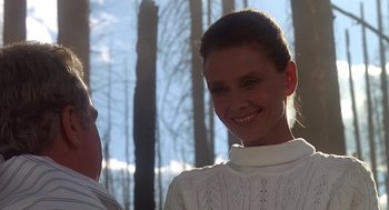 Movie still from “Always” (1989), directed by Steven Spielberg – A woman in a white sweater smiling for the camera; Close Up shot, Over the shoulder angle