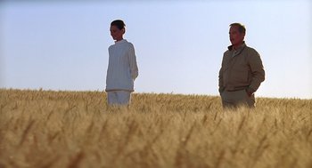 Movie still from “Always” (1989), directed by Steven Spielberg – A man and a woman standing in a wheat field; Wide shot, Low angle