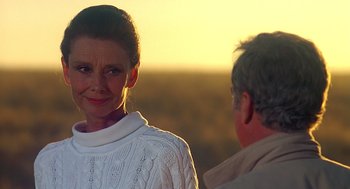 Movie still from “Always” (1989), directed by Steven Spielberg – An older man and a younger woman standing next to each other; Close Up shot, Over the shoulder angle