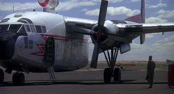 Movie still from “Always” (1989), directed by Steven Spielberg – An old airplane is sitting on the tarmac; Wide shot, Low angle