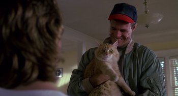 Movie still from “Always” (1989), directed by Steven Spielberg – A man holding an orange cat in his arms; Medium shot, Low angle