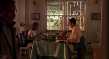 Movie still from “Always” (1989), directed by Steven Spielberg – A man and a woman sitting at a dinner table; Wide shot, Low angle