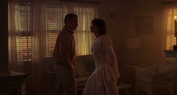 Movie still from “Always” (1989), directed by Steven Spielberg – A man and a woman standing next to each other in a room; Medium shot, Over the shoulder angle