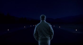 Movie still from “Always” (1989), directed by Steven Spielberg – A man standing in front of a field at night; Wide shot, Low angle